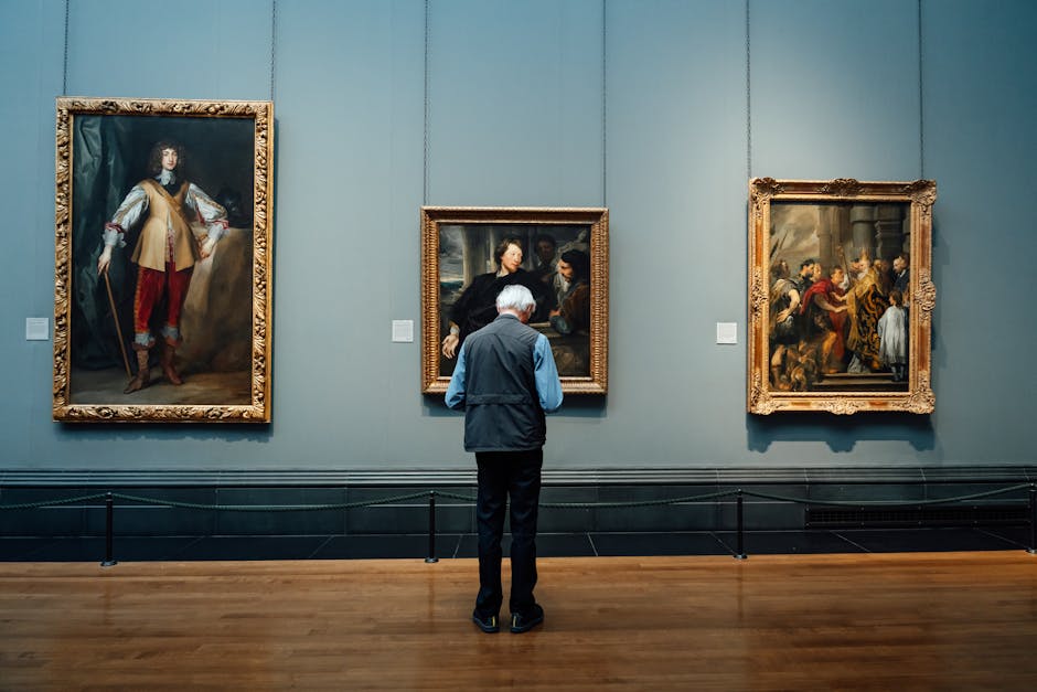 An elderly man admires classic paintings at an art gallery in England. Indoor lighting enhances the historic ambiance.