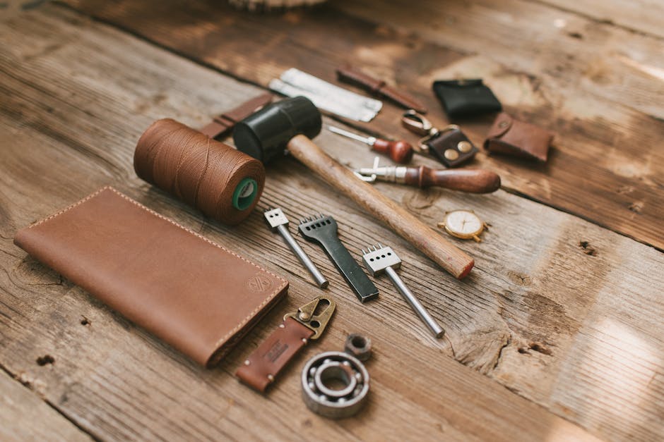 A collection of leather crafting tools neatly arranged on a wooden surface, emphasizing traditional craftsmanship.
